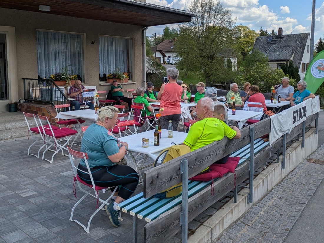 Wanderer an Tischen auf der Terrasse am Konsum